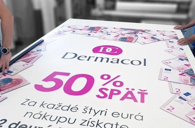 Veľký potlačený banner rozložený na stole v tlačiarni pred konfekciou