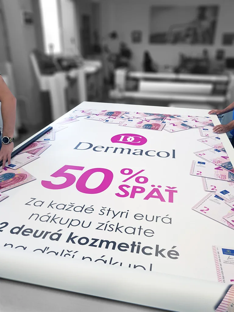 Veľký potlačený banner rozložený na stole v tlačiarni pred konfekciou
