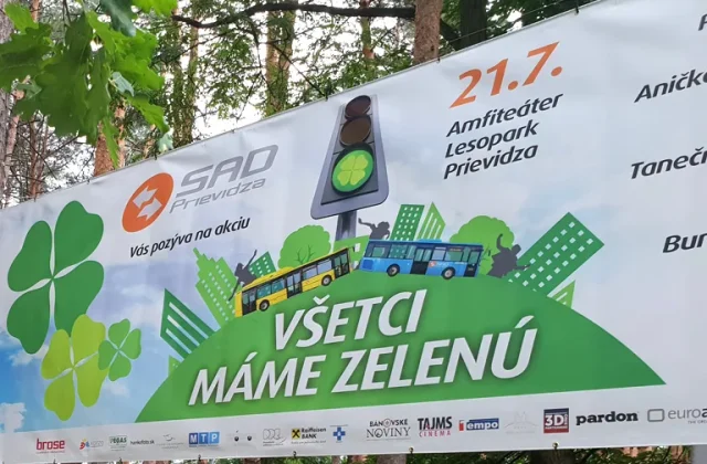 Veľkoplošný banner s pozvánkou na podujatie napnutý medzi stromami v lesoparku