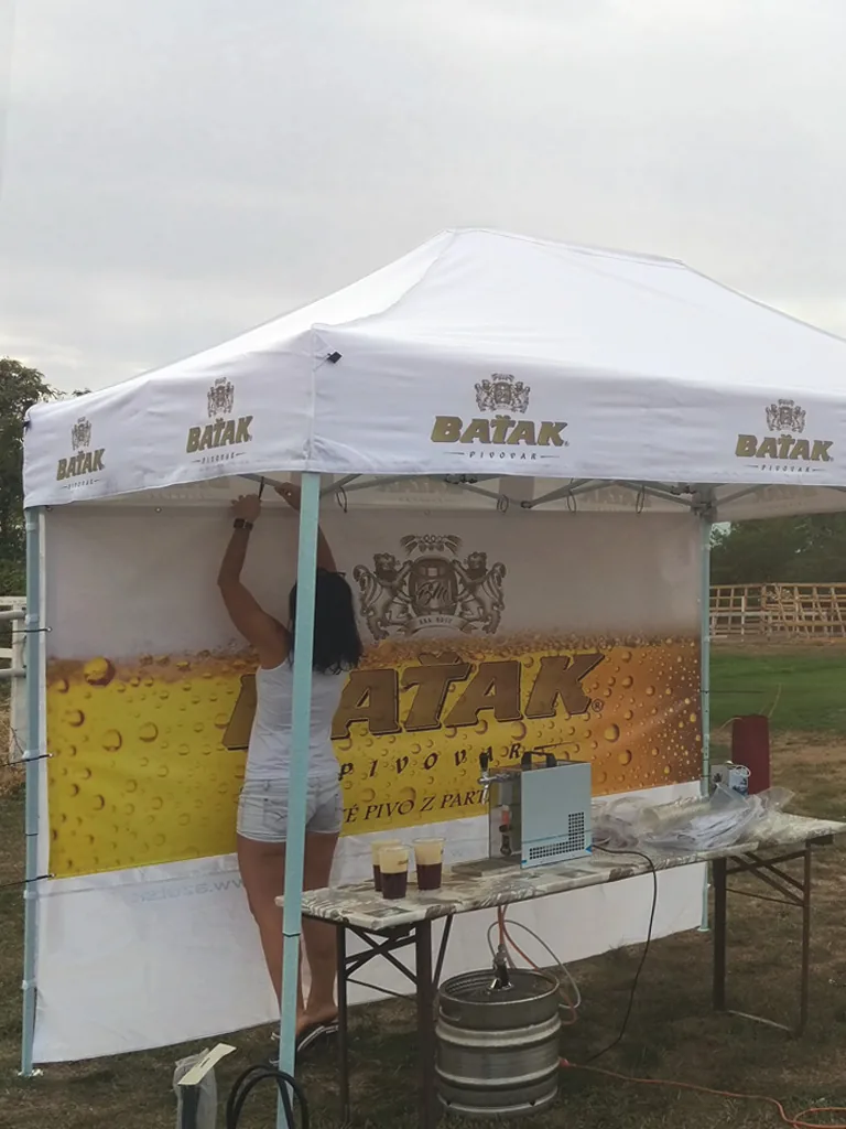 Reklamný predajný stan s potlačenou strieškou a bočným bannerom na podujatí