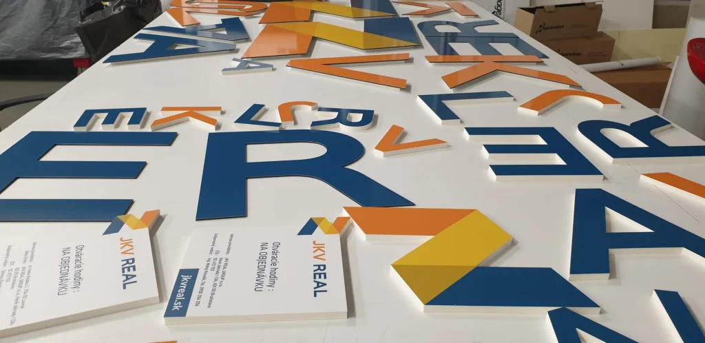 Vyrezané farebné písmená a tlačoviny firemnej identity na stole