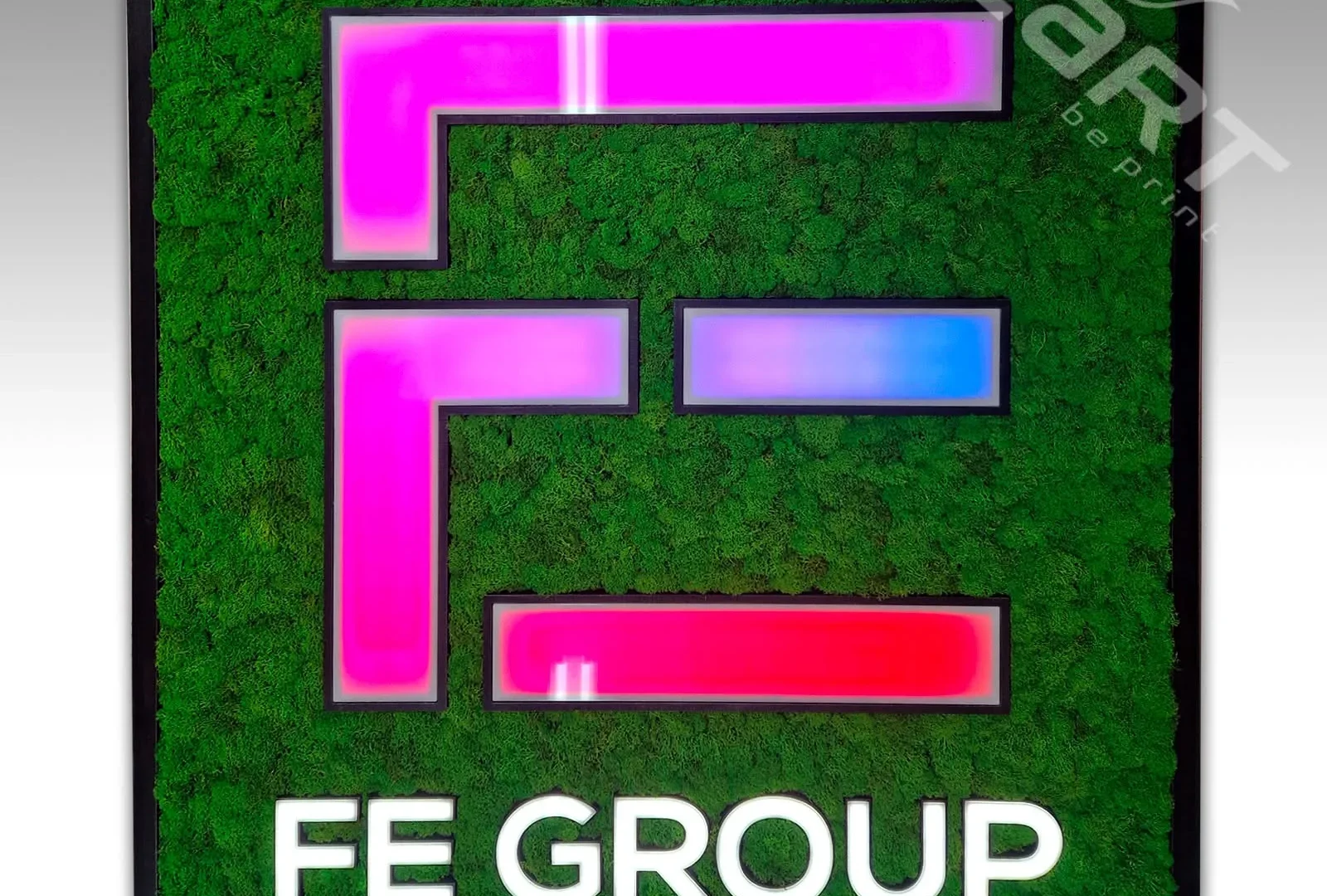 Machový obraz s logom FE Group podsvieteným adresovateľnými RGBW pixel LED v ružovo-modrej scéne