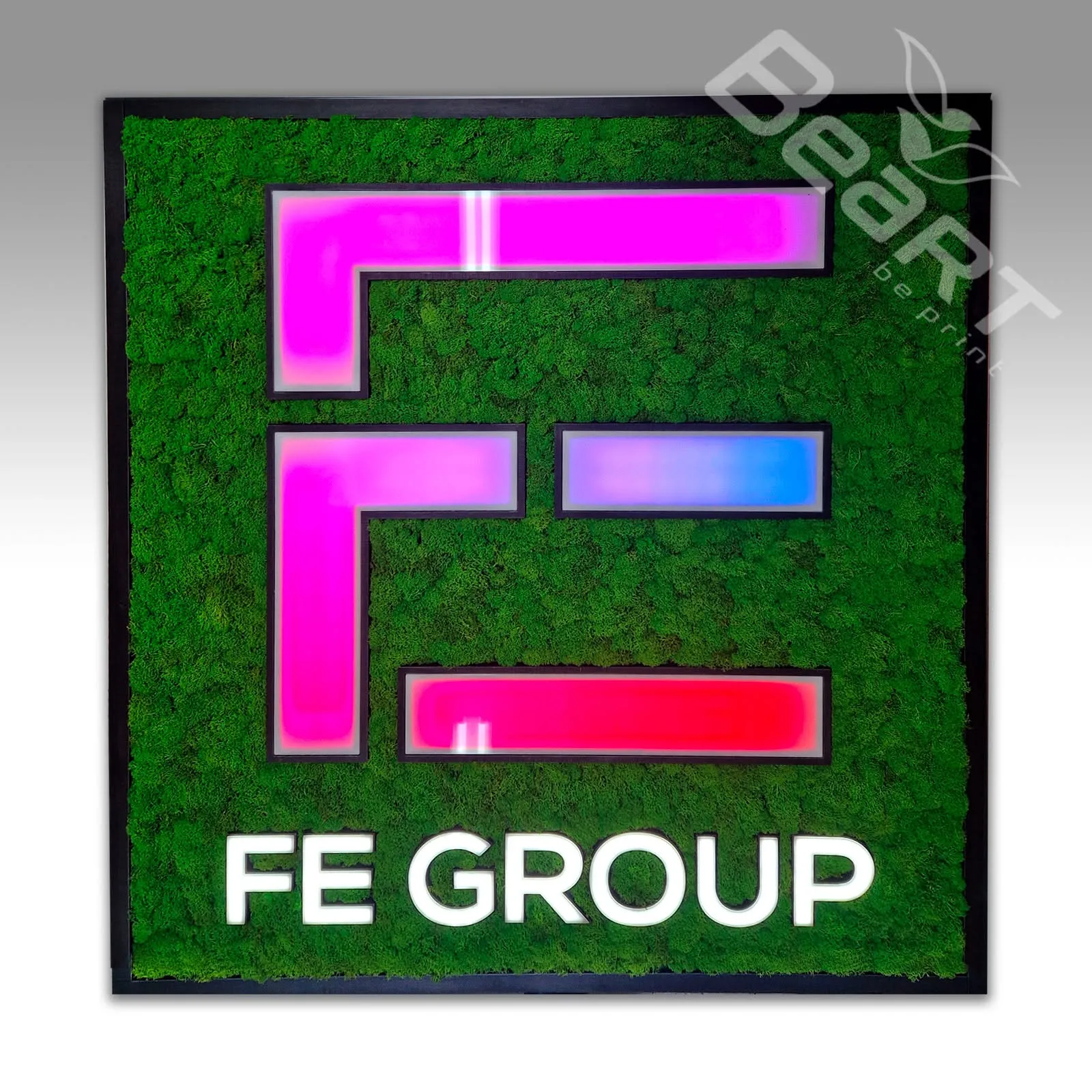 Štvorcový machový obraz s podsvieteným logom FE Group v ružovo-modrej farbe