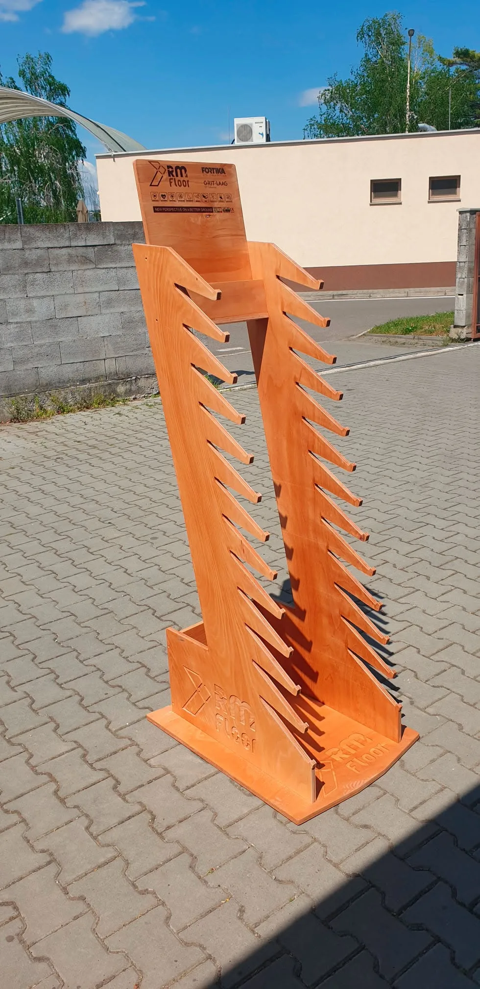 Hotový drevený prezentačný stojan s frézovaným logom a lištami na vzorky podláh