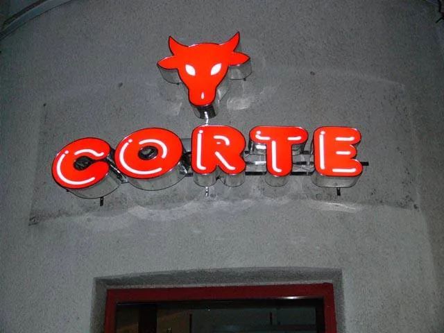 Svietiace červené 3D písmená s logom býka na fasáde