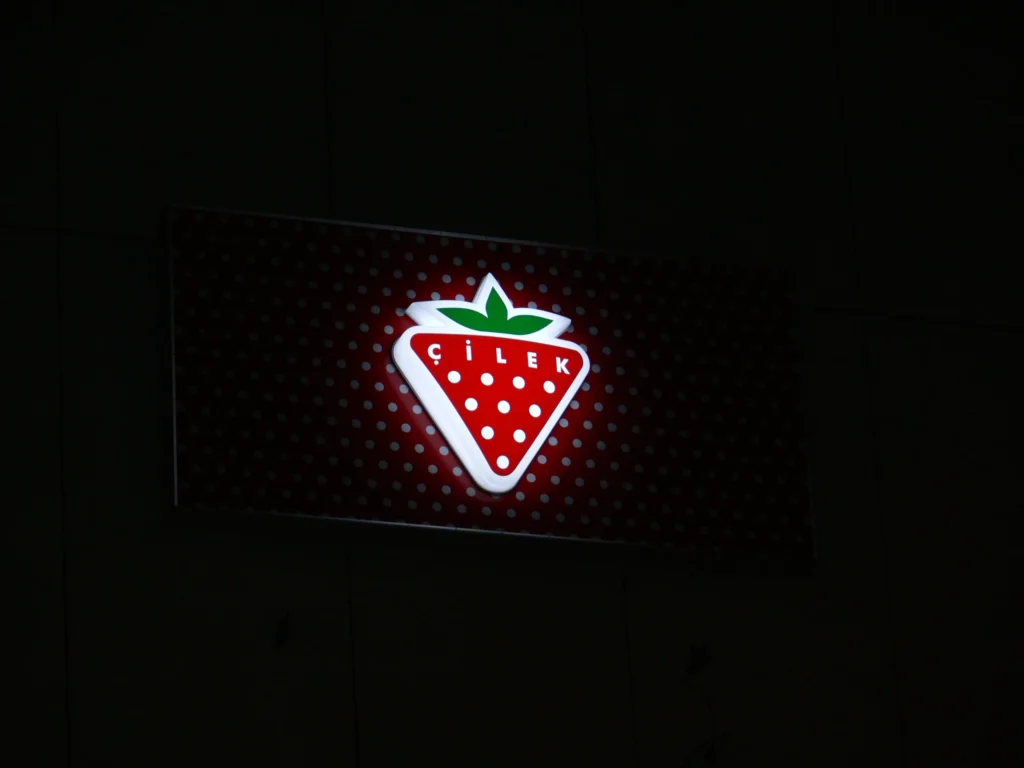 Svietiaci panel s logom jahody v noci