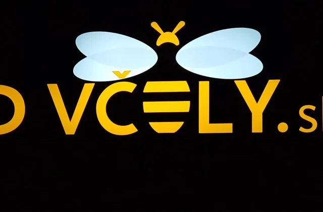 Rozsvietený nápis Od včely.sk s logom včely, žltý text a biele krídla žiaria v tme